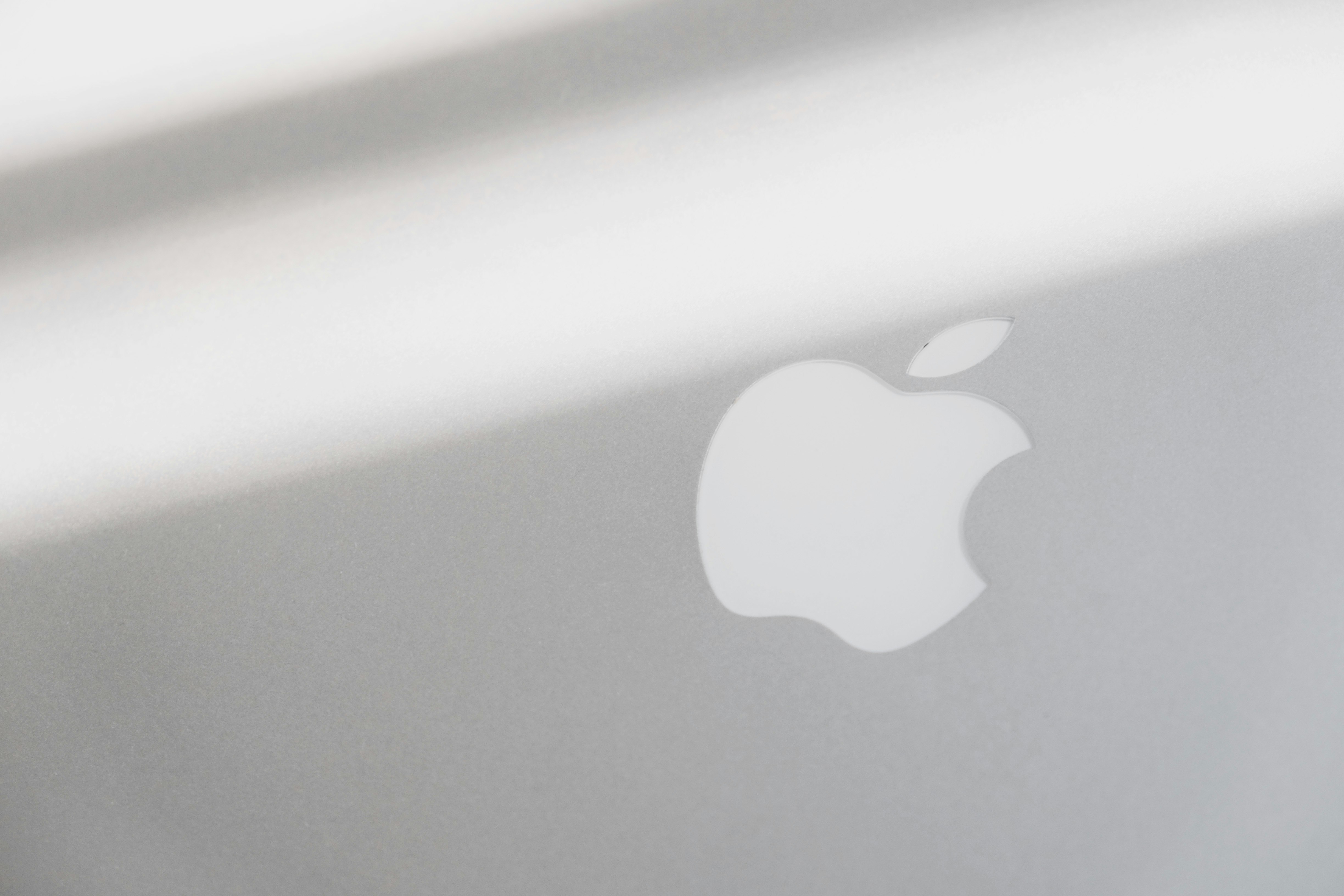 silver macbook on white table